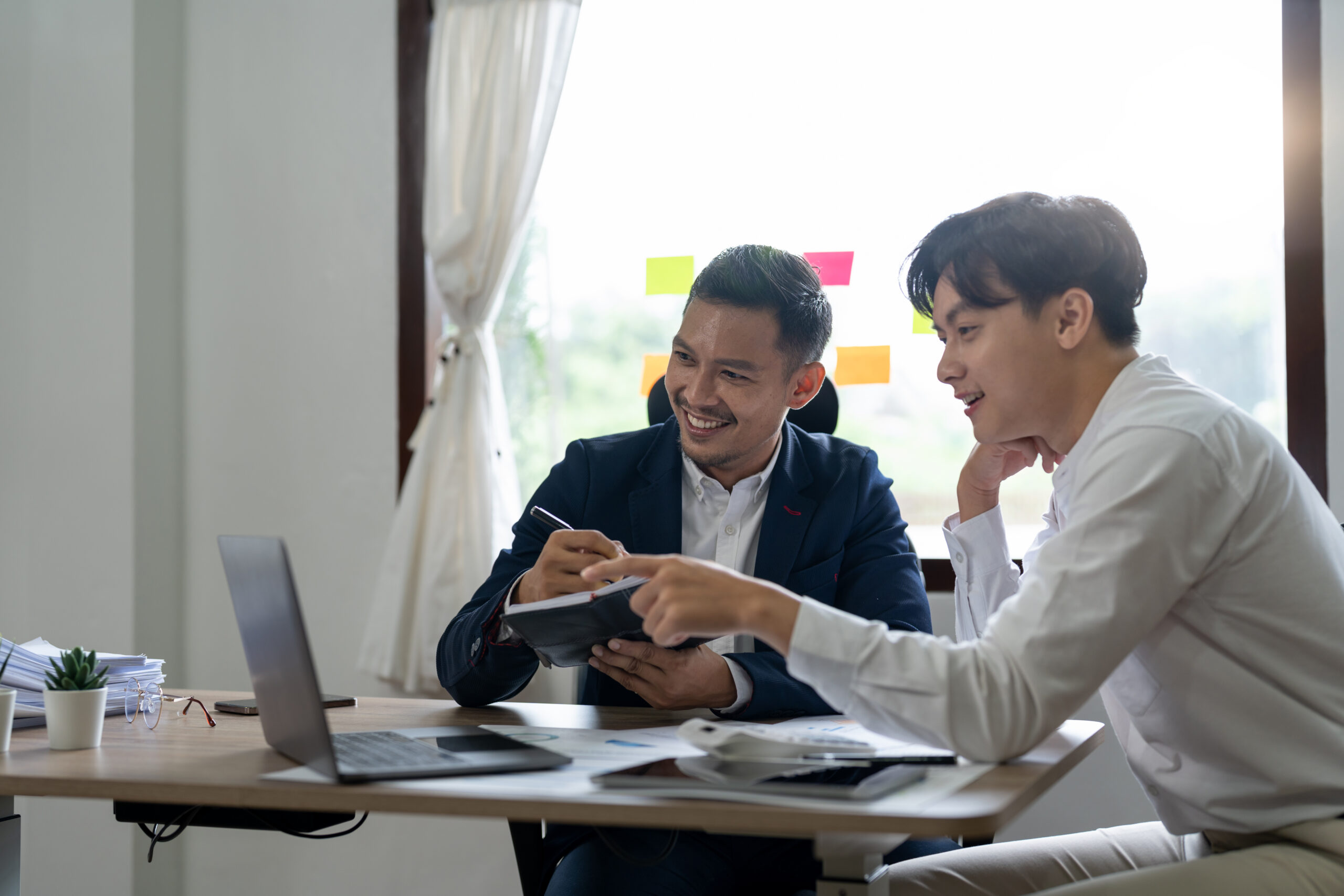 Asian business professionals discussing Wi-Fi network solutions in a meeting